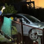 a-car-suspended-over-a-3m-drop-between-a-house-and-retaining-KXU34SAHARDFDG3524U3KZHSBA